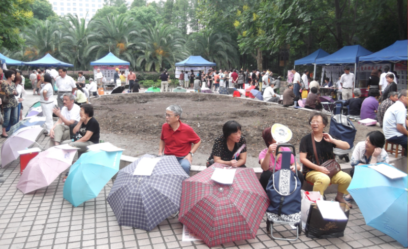 está en un parque lleno de padres con sombrillas
 – Tinta clara